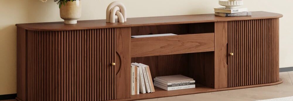 Buffet en bois avec portes et tiroirs texturés coulissantes, vase blanc, livre et art mural minimaliste.