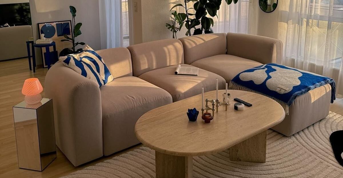 canapé d'angle avec cousin et plaid bleu électrique et blanc avec table basse cubique en bois
