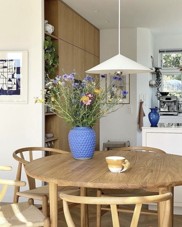 table et chaises en bois avec lustre pendant blanc en triangle